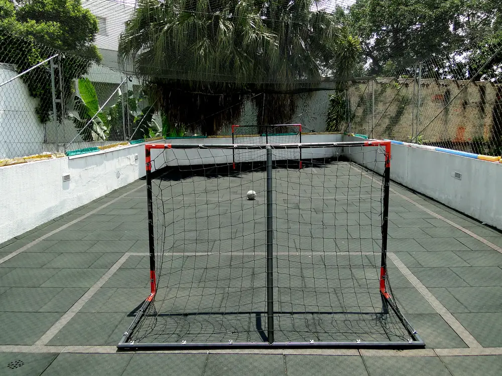 Quadra poliesportiva com traves e tela de proteção