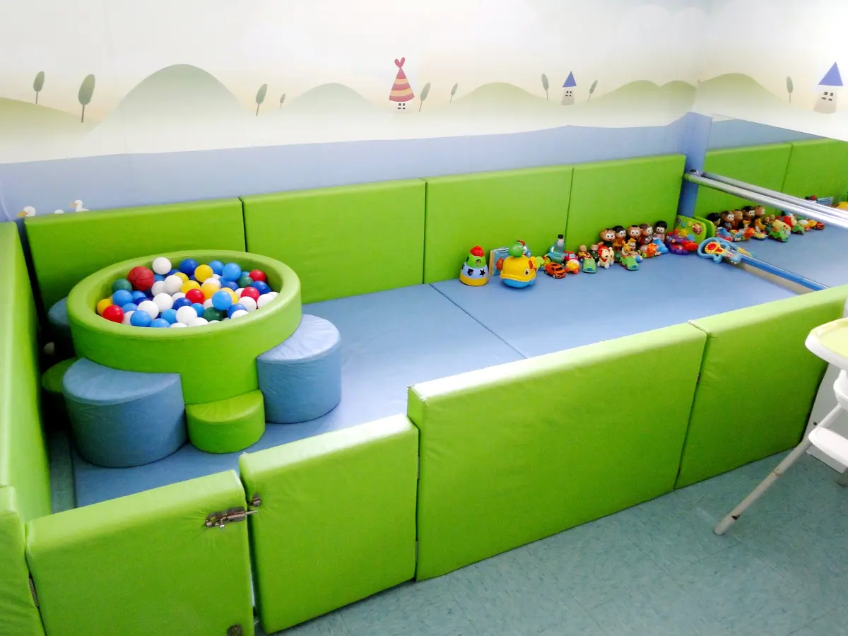 Sala sensorial com colchonetes verdes e piscina de bolinhas