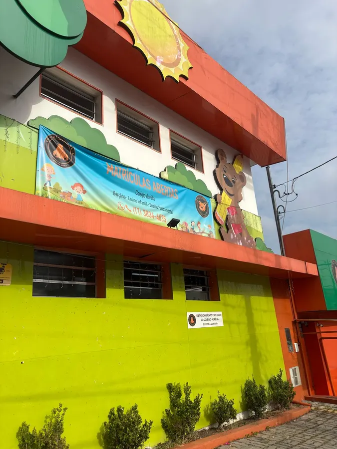 Fachada colorida do Colégio Aurélia na Vila Romana, com mural pintado e jardim na entrada